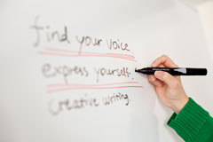 Image of person writing on a whiteboard Image of person writing on a whiteboard