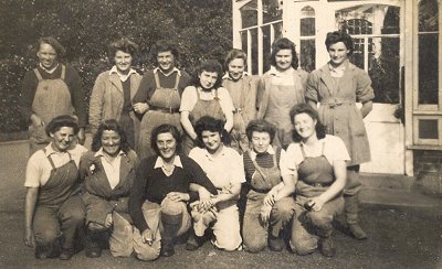 Group of Land Girls in front of greenhouse at Luton Hoo