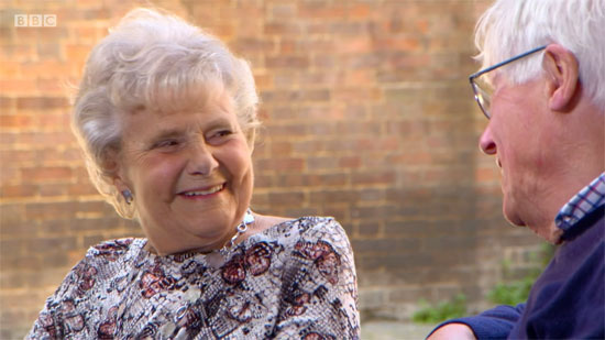 Screenshot of Zeita Holes being interviewed by TV presenter John Craven about her dairy training for the WLA in 1942