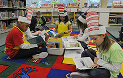 Children with homemade Dr Suess hats on reading