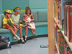 Three children reading in the library