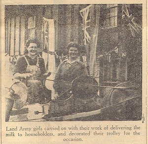 Land girls with a decorated milk trolley