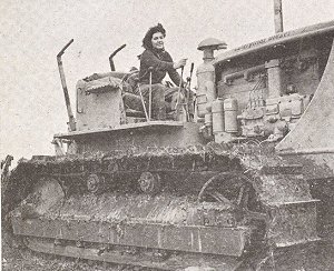 Land girl operating caterpillar tractor