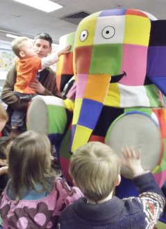 Photo of Elmer visiting the library with children